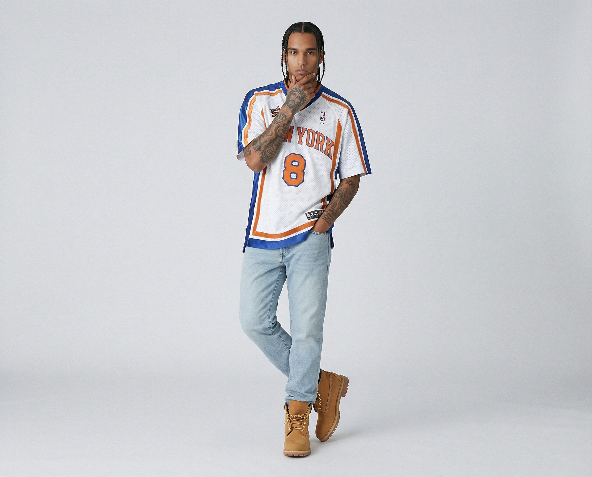 Generated with Kive.ai - with jesus tattoos on his arm with one foot behind the other leg_ one hand in the pocket the other touching his chin..png