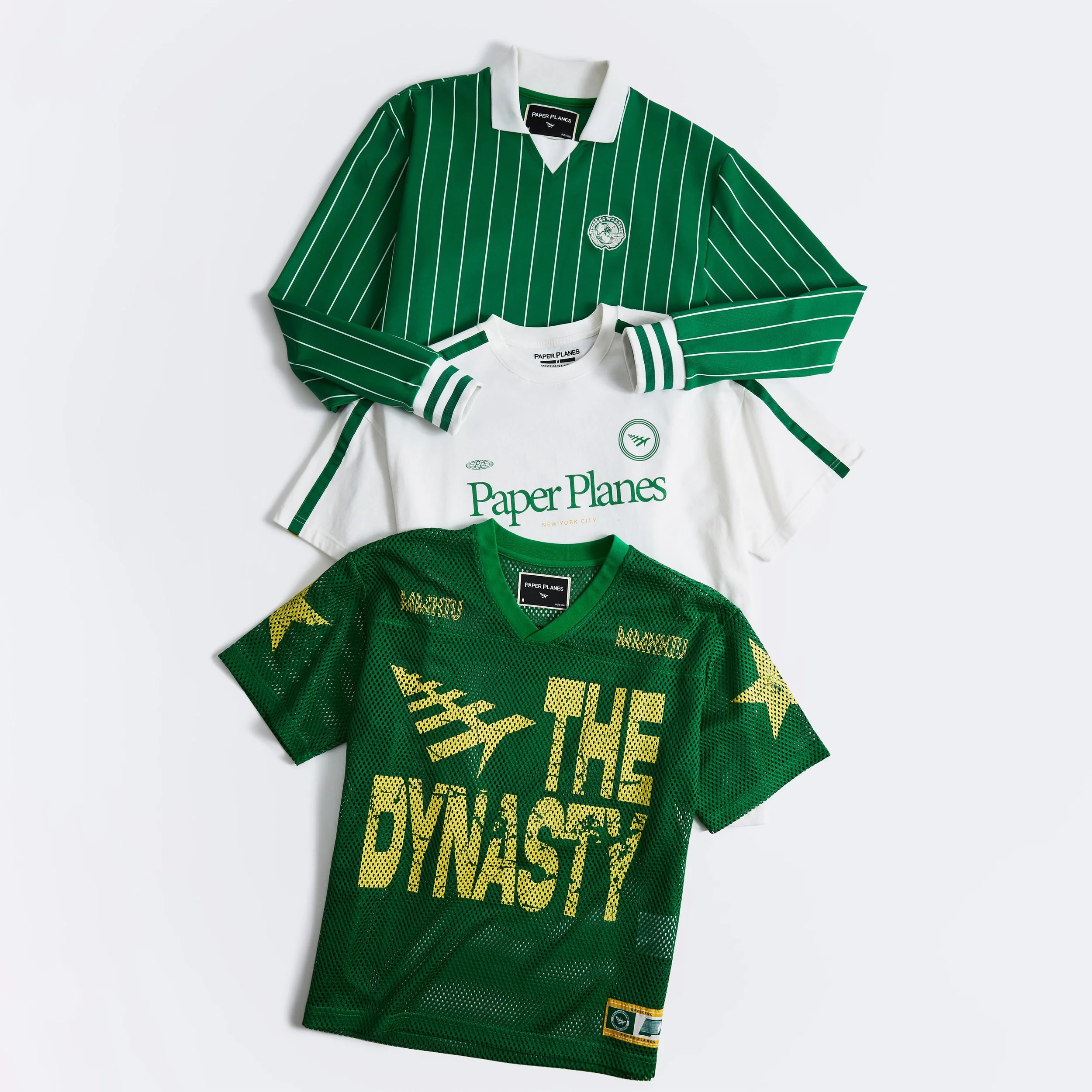 Green sports jersey with yellow accents, and a matching green jersey with yellow graphics, laid on a white background.