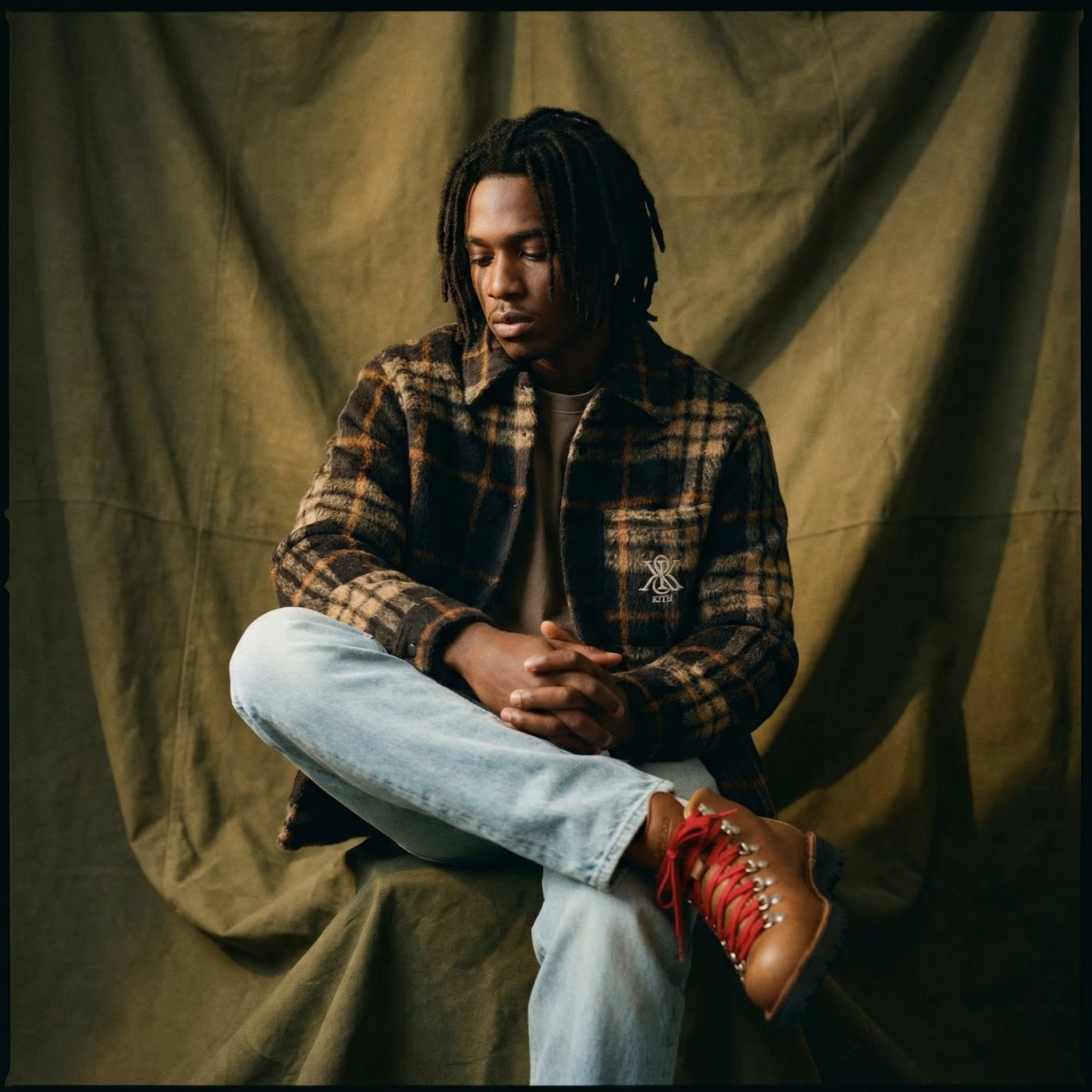 Generated with Kive.ai - Young Black man with dreadlocks_ contemplative expression_ olive canvas backdrop with dramatic folds_ chiaroscuro lighting_ warm tungsten glow_ shallow depth of field_ medium format portrait_ Kodak Portra 400_ n (1).png