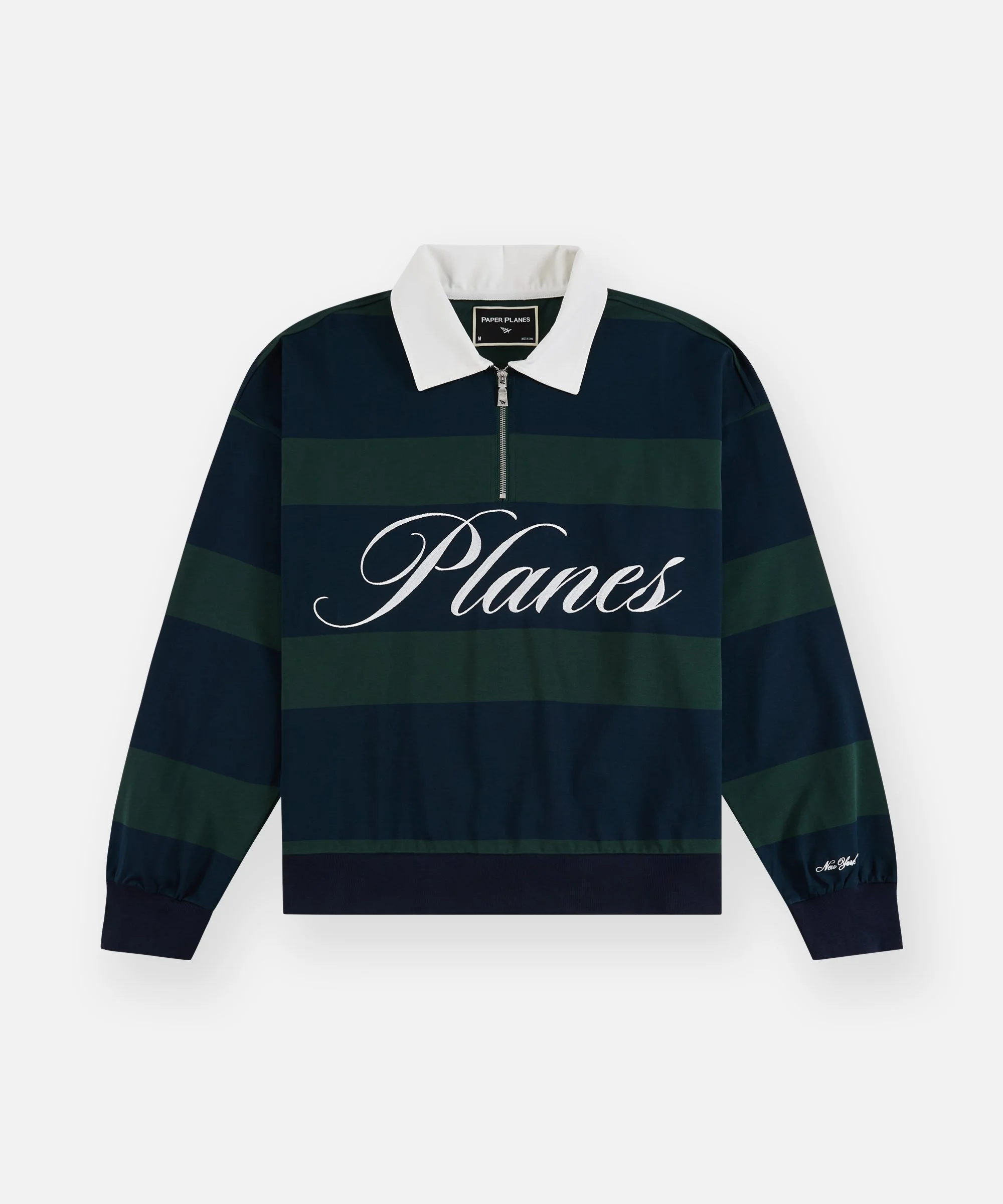 A navy blue and green striped rugby shirt with a white collar and a front zipper. 'Planes' is written in cursive across the front, and 'New York' is embroidered on the left sleeve.