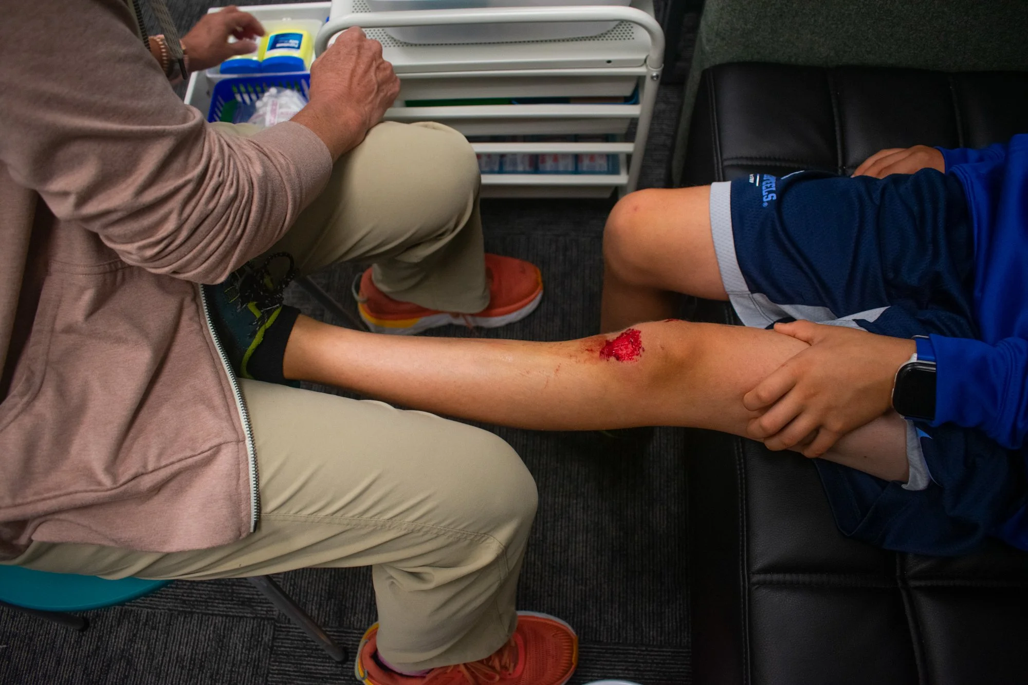 Minogue cleans a student’s bloody knee after he tripped on the way to class. Last year, she averaged about 10 to 11 patients a day and does not take an hour-long lunch, as she must remain available at all times. She said the responsibility at McDougl