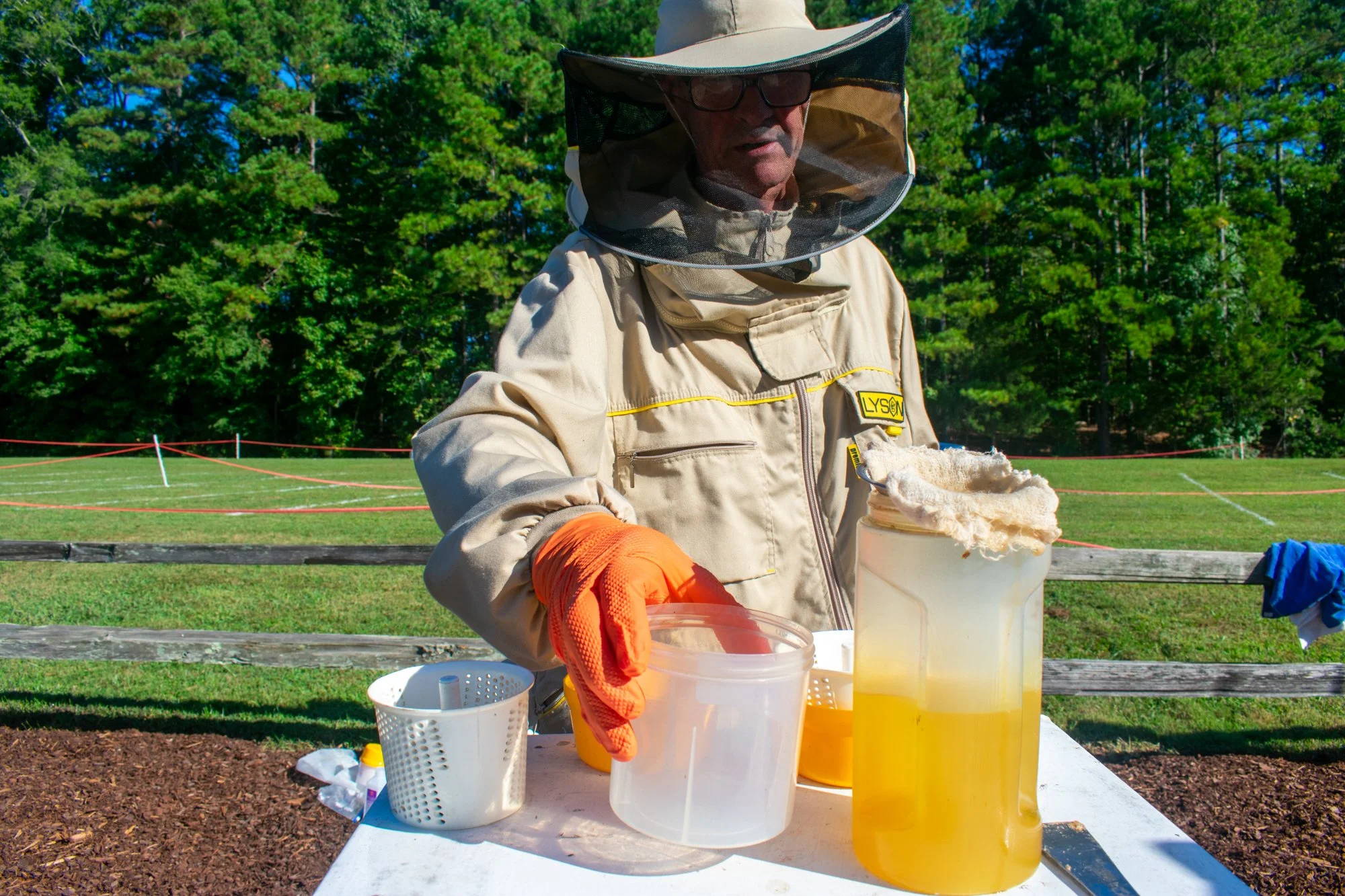 Andrew Ford, a member of the OCBA, creates an alcohol wash to inspect the hive for varroa mites, parasites that originated in Asia and came to the United States in the 1980s that carry harmful viruses. The viruses, including deformed wing virus, can 