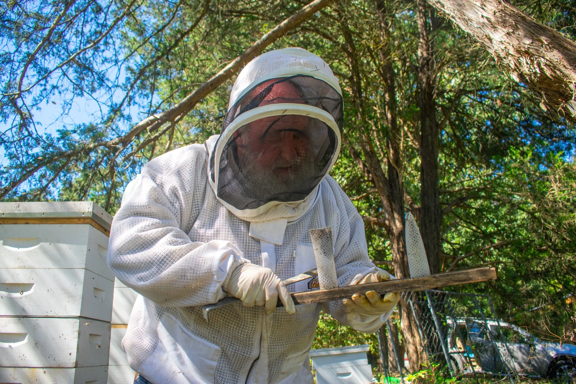 Crump cleans out feeders that he fills with sugar water to feed bees when there isn’t enough nectar. Bees make honey from the nectar they collect from flowers, but there are times during the year when nectar is scarce, a period called the dearth acco