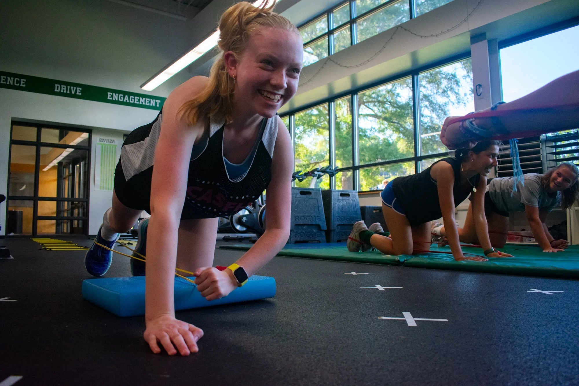 Freshman Kate Holladay stretches her leg with a resistance band during weight training. The team went to the weight room two to three times a week for thirty minutes after practice. They worked on speed, agility and strength. In the preseason, the te