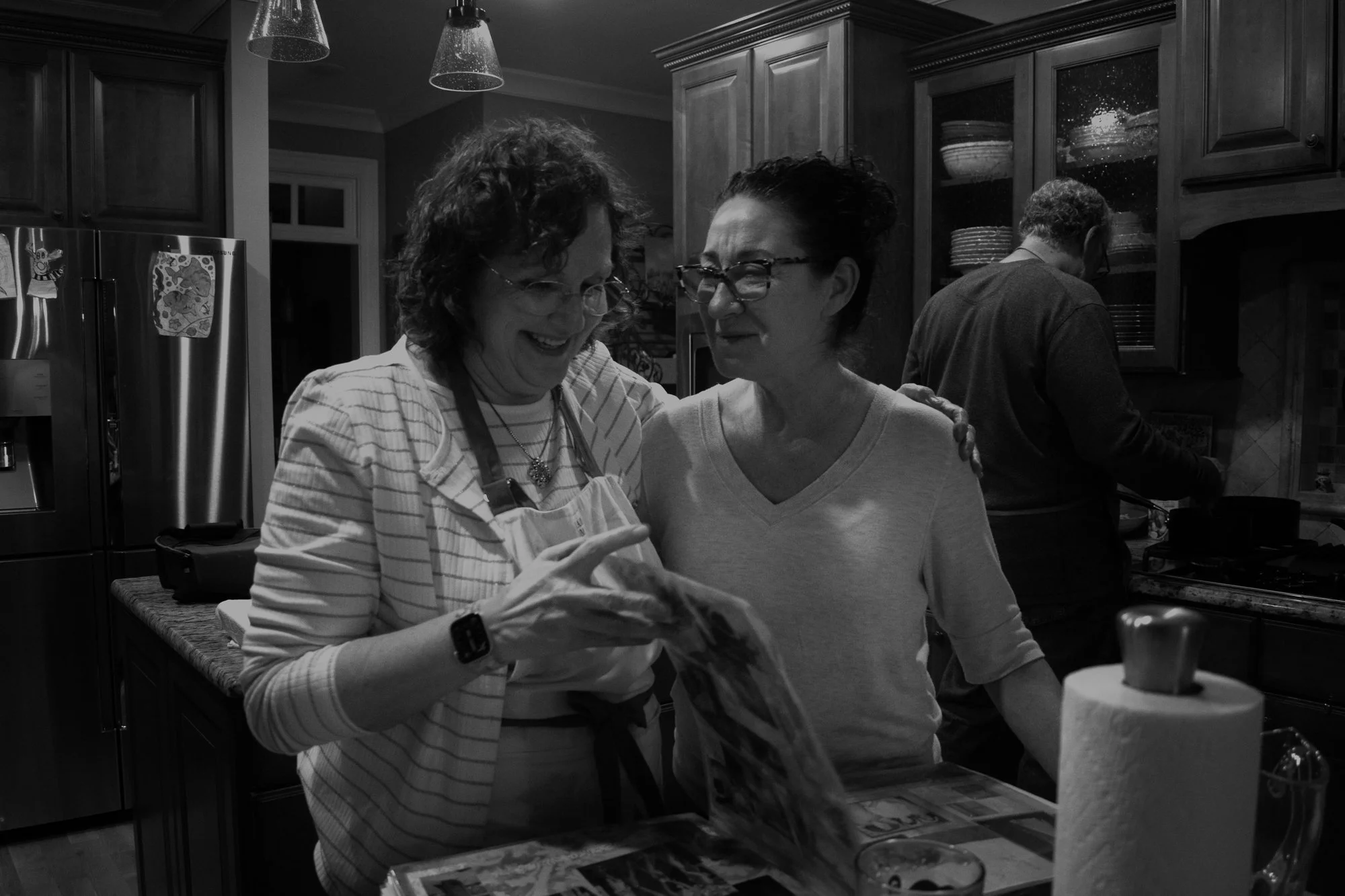 Tina looks through old photo albums with her close neighborhood friend Nancy Sadick before they eat dinner together. Due to the intense time commitment caregiving requires, Tina has to be very intentional when trying to find time for herself to do wh