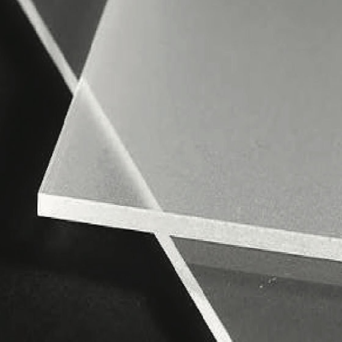 Close-up of a corner of a silver, metallic sheet resting on a black surface.