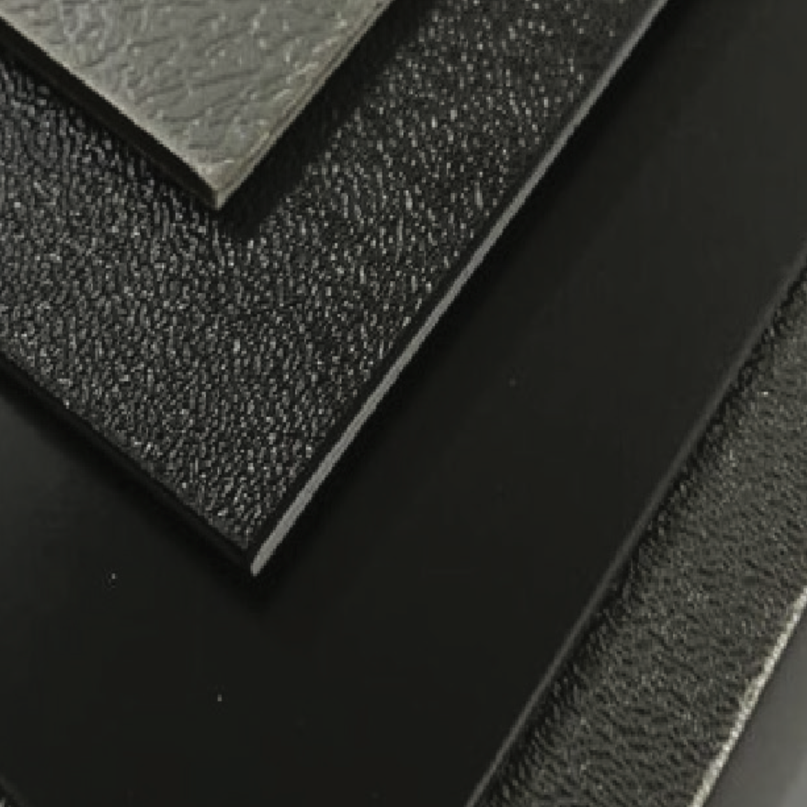 Close-up of a metallic switch or lever on a textured black surface.