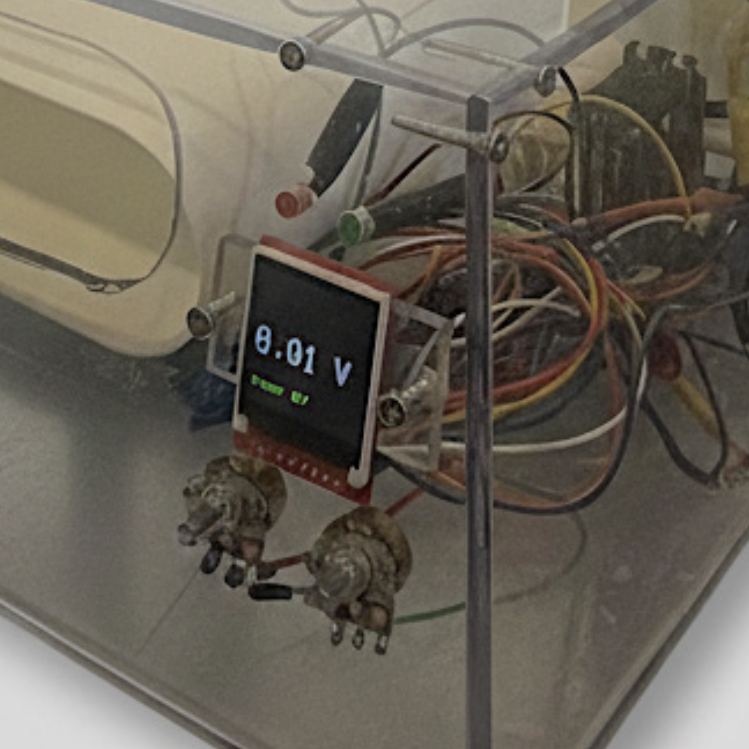 A scientific device with a digital display showing '8.01 V' and 'Status OK', surrounded by wires, knobs, and metal support structures.