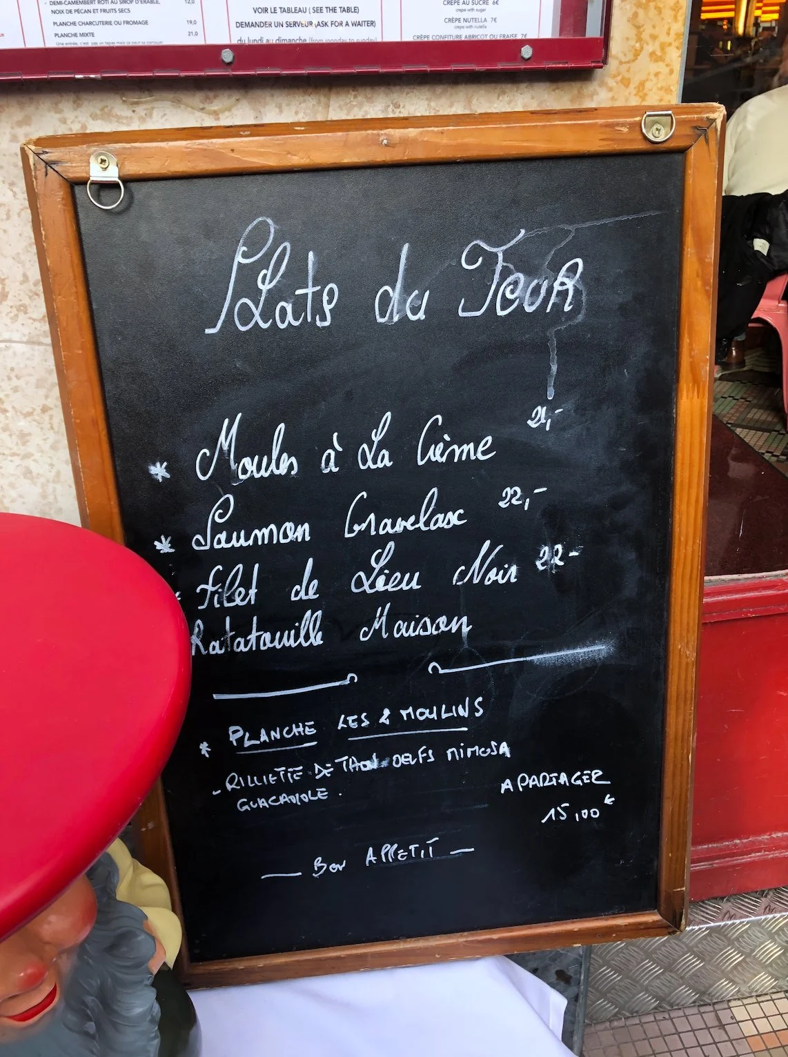 French menu board with handwritten items including cream mussels, salmon gravlax, and local trout fillet, with additional options below.