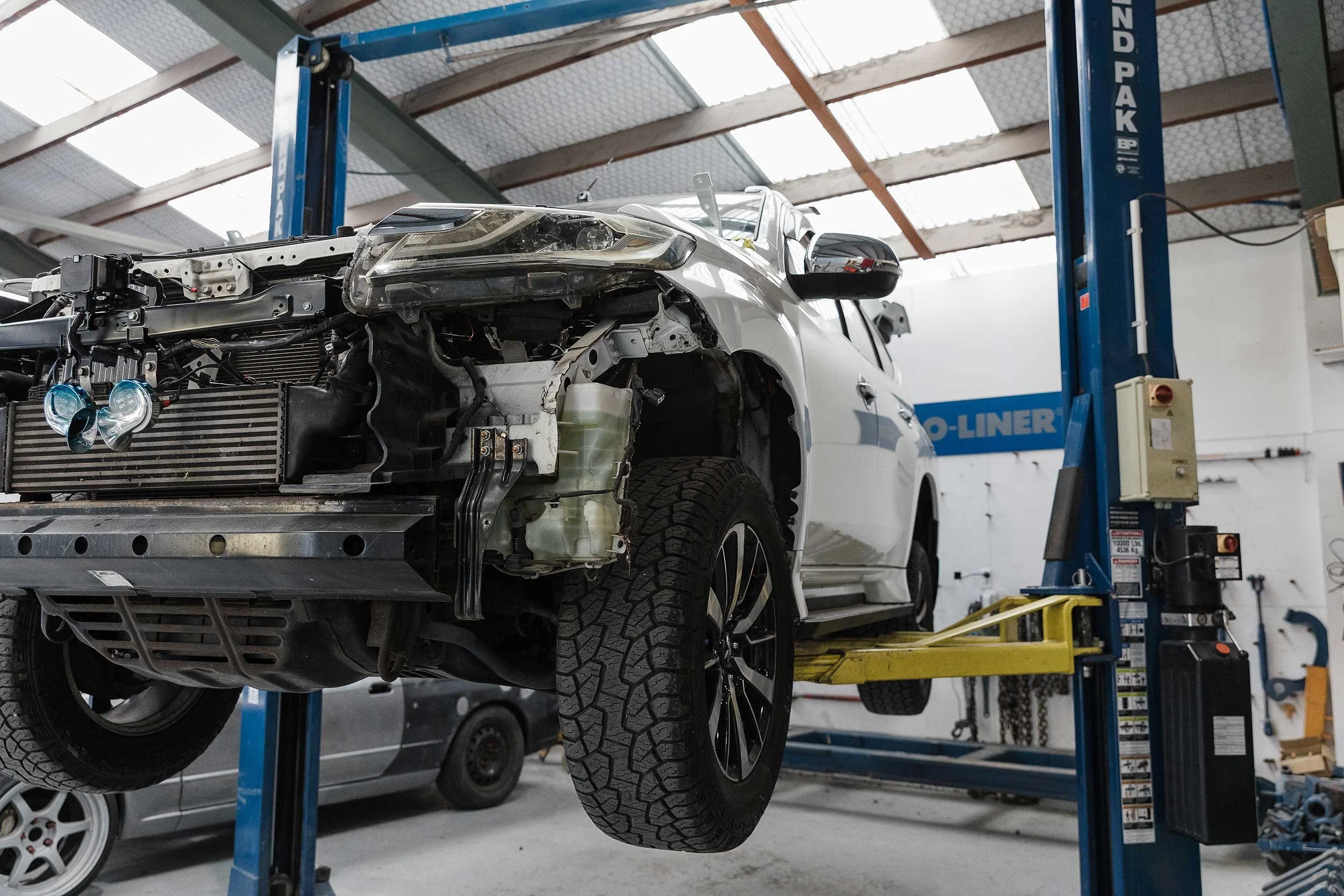 Crashed car on a hoist being repaired at A&M Panel Repairs in Napier