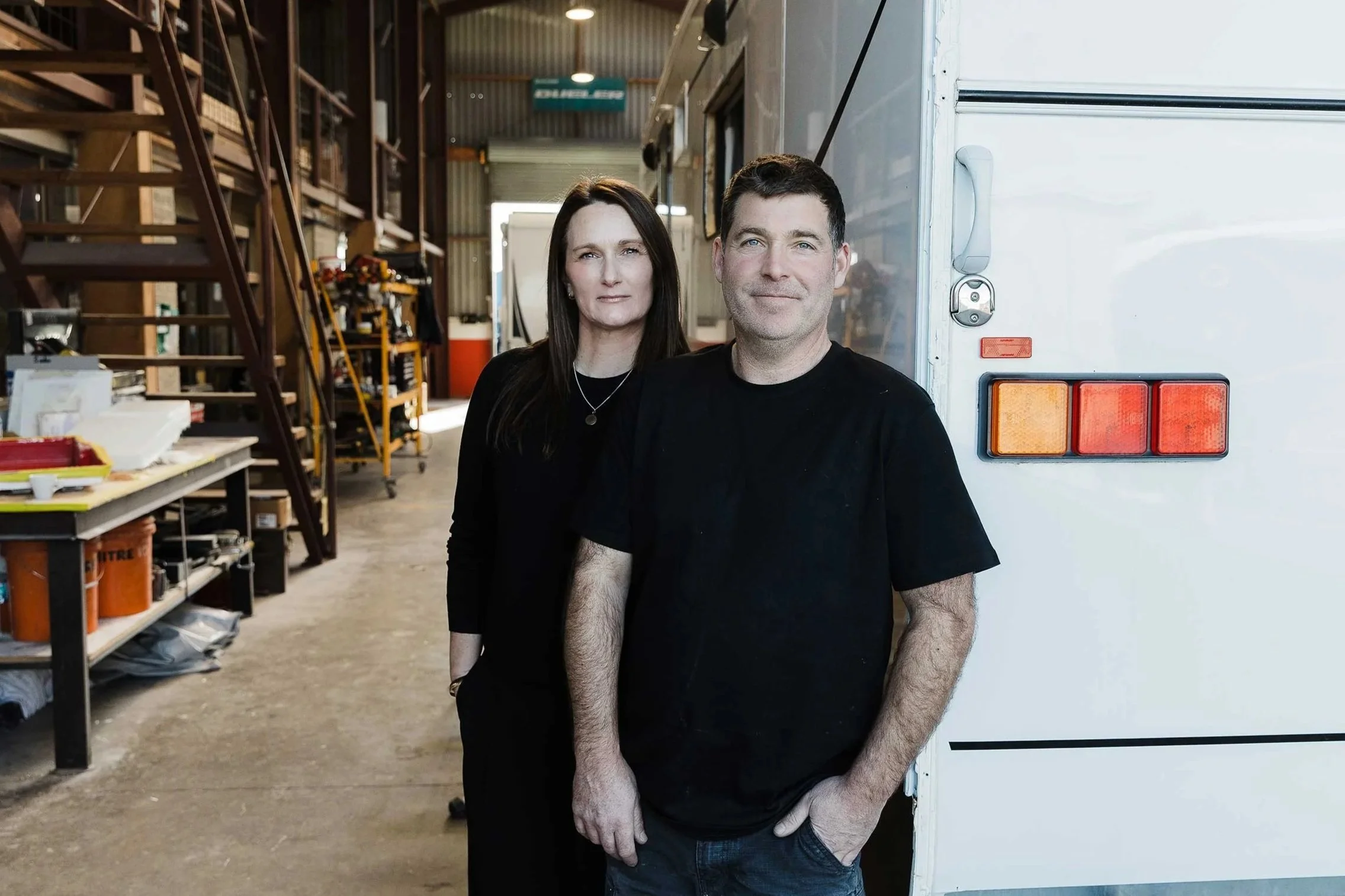 Tim and Shelley McDougal - Owners at A&M Panel Repairs in Napier, standing next to Campervan in the repair workshop