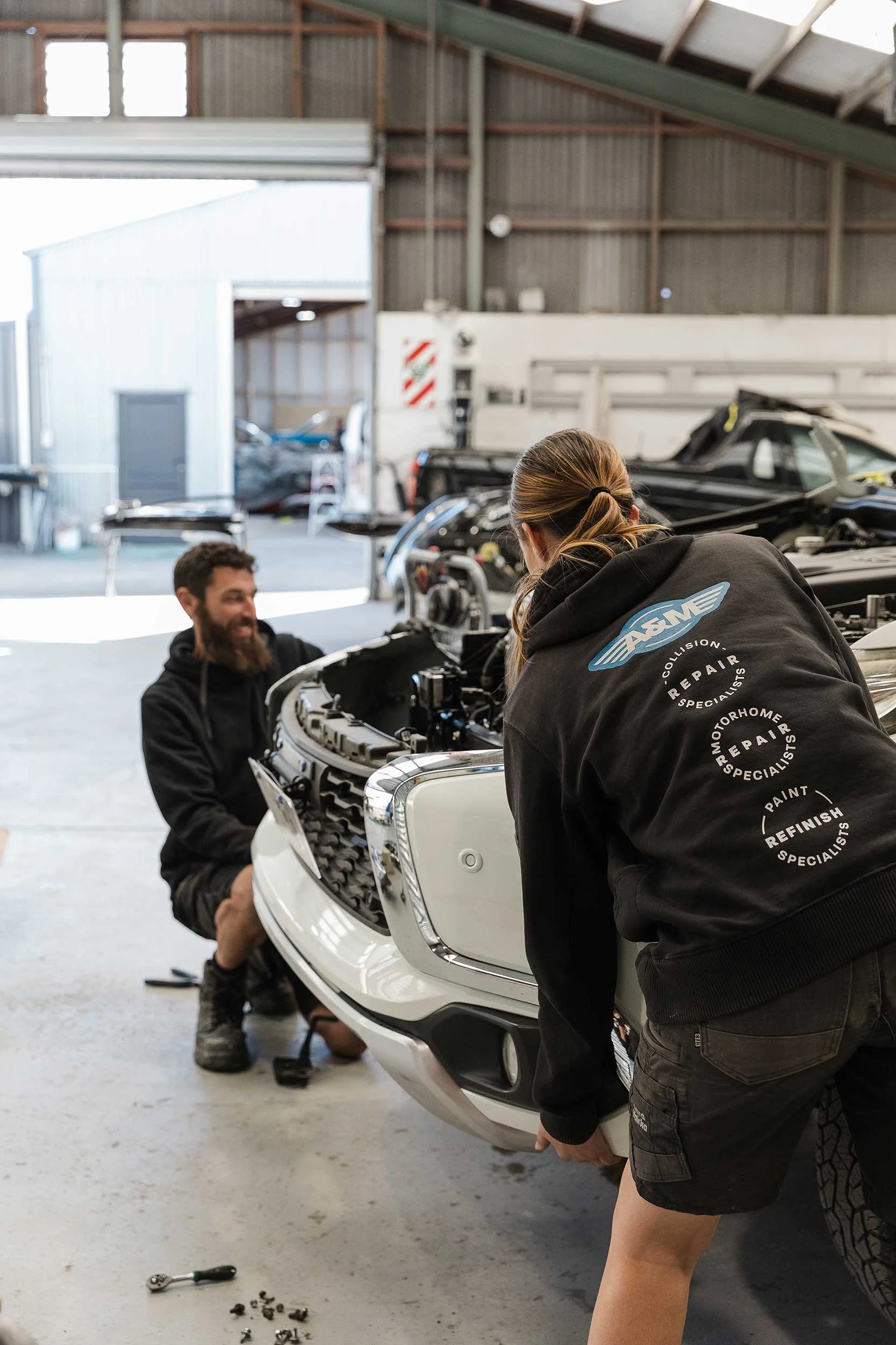 A&M crash and collison repair team in Napier fitting repaired bumper to vehicle