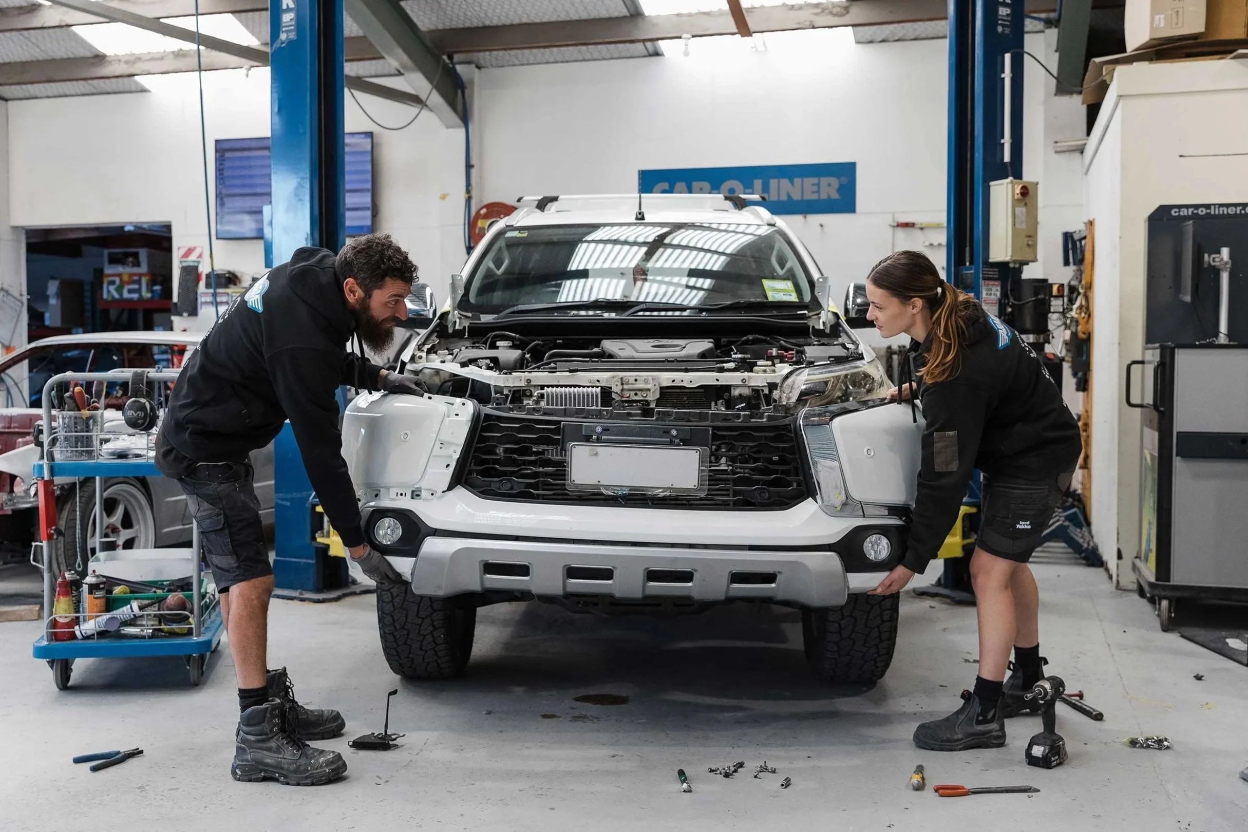 A&M Panel Repair team attaching bumper to accident damaged vehicle