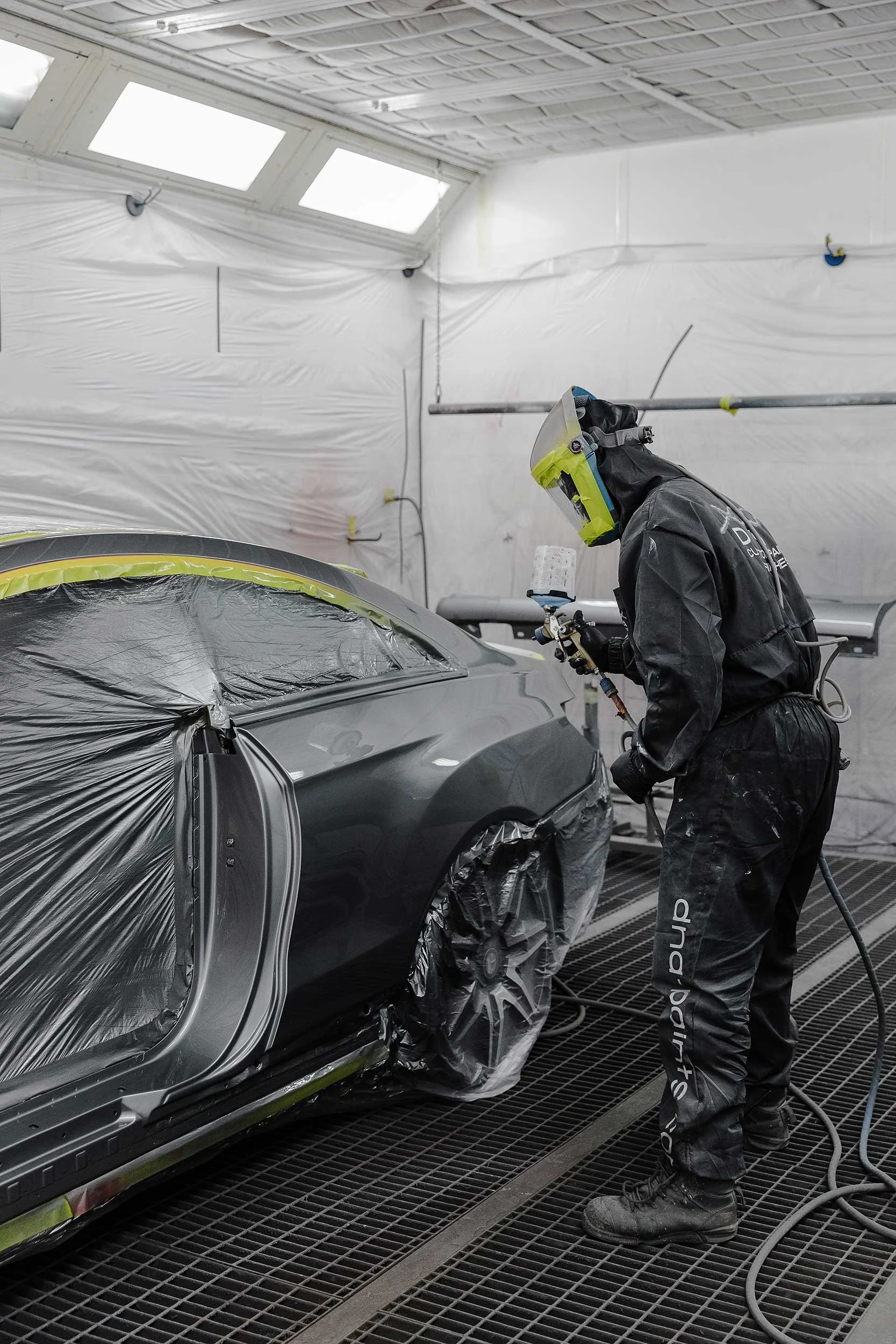 Car painter completing a high grade eco-friendly paint finish on a grey car at A&M Panel Repairs high grade paint facility