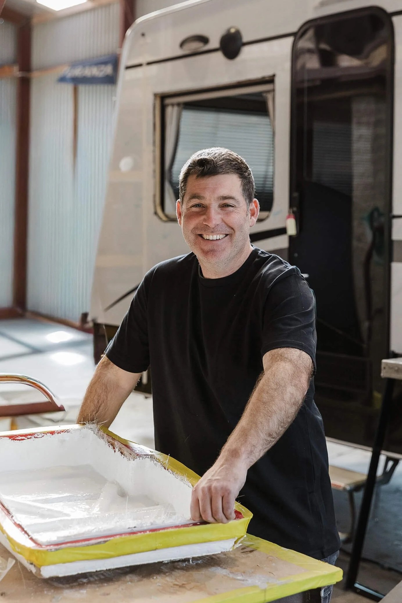 Tim McDougal, owner of A&M Panel Repairs, working on a fiberglass motorhome repair in his Napier workshop.