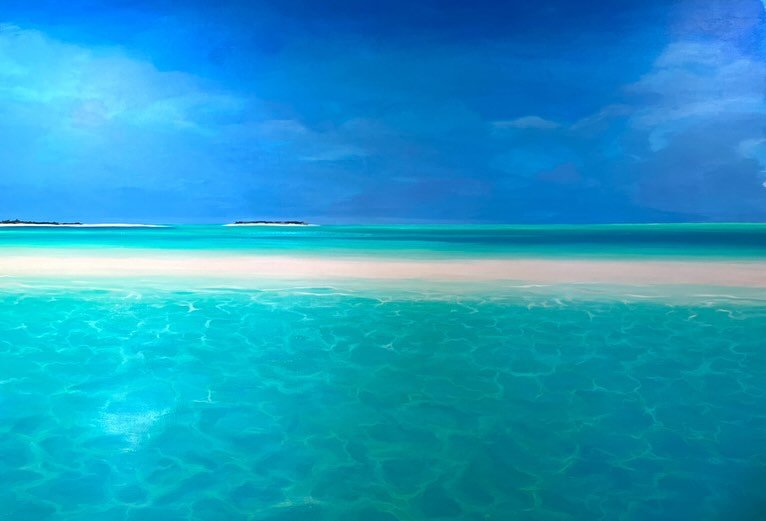 A serene tropical beach with turquoise water, white sand, and a blue sky with some clouds.