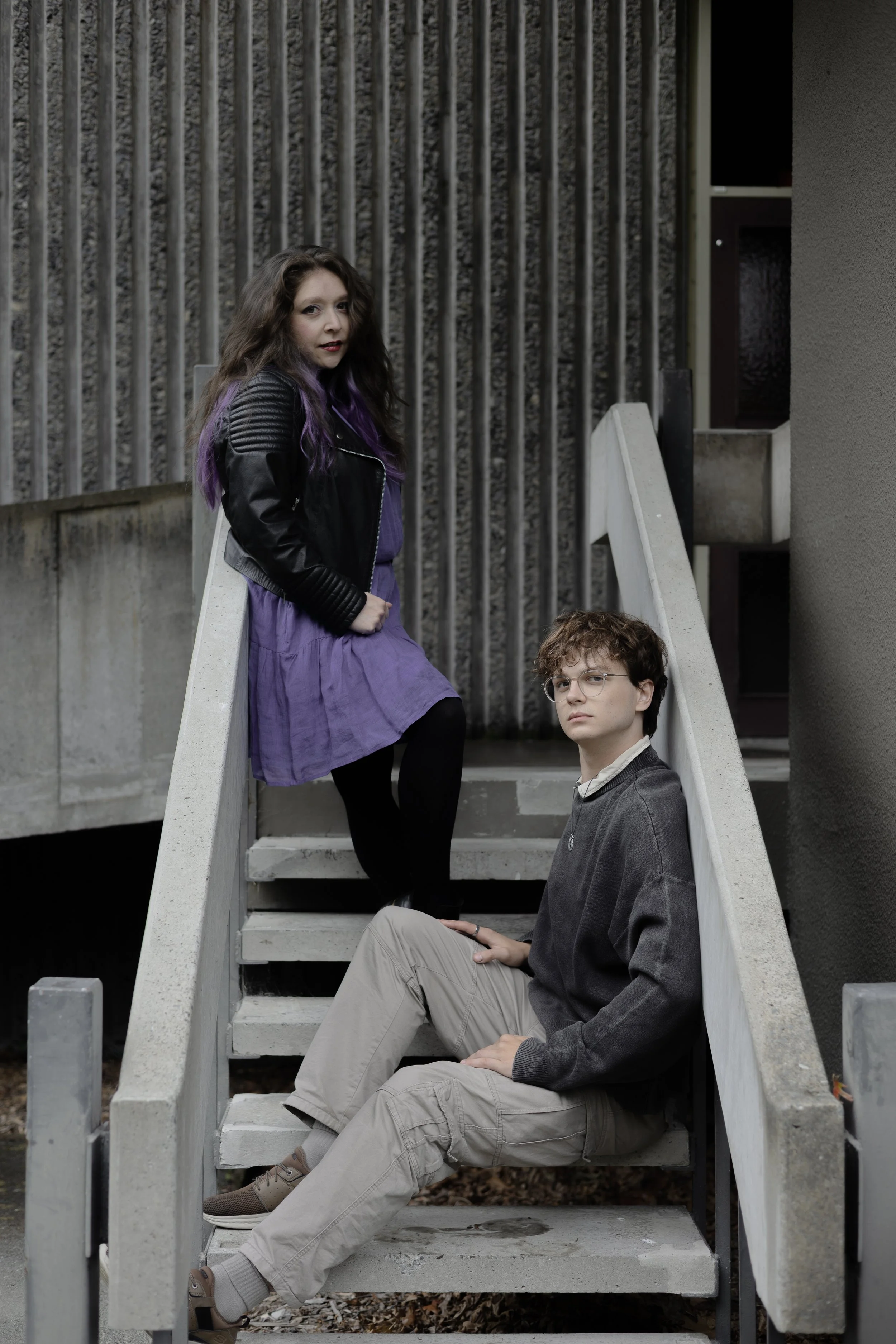 A happy couple hugging and smiling outdoors with lush green trees and sunlight in the background.