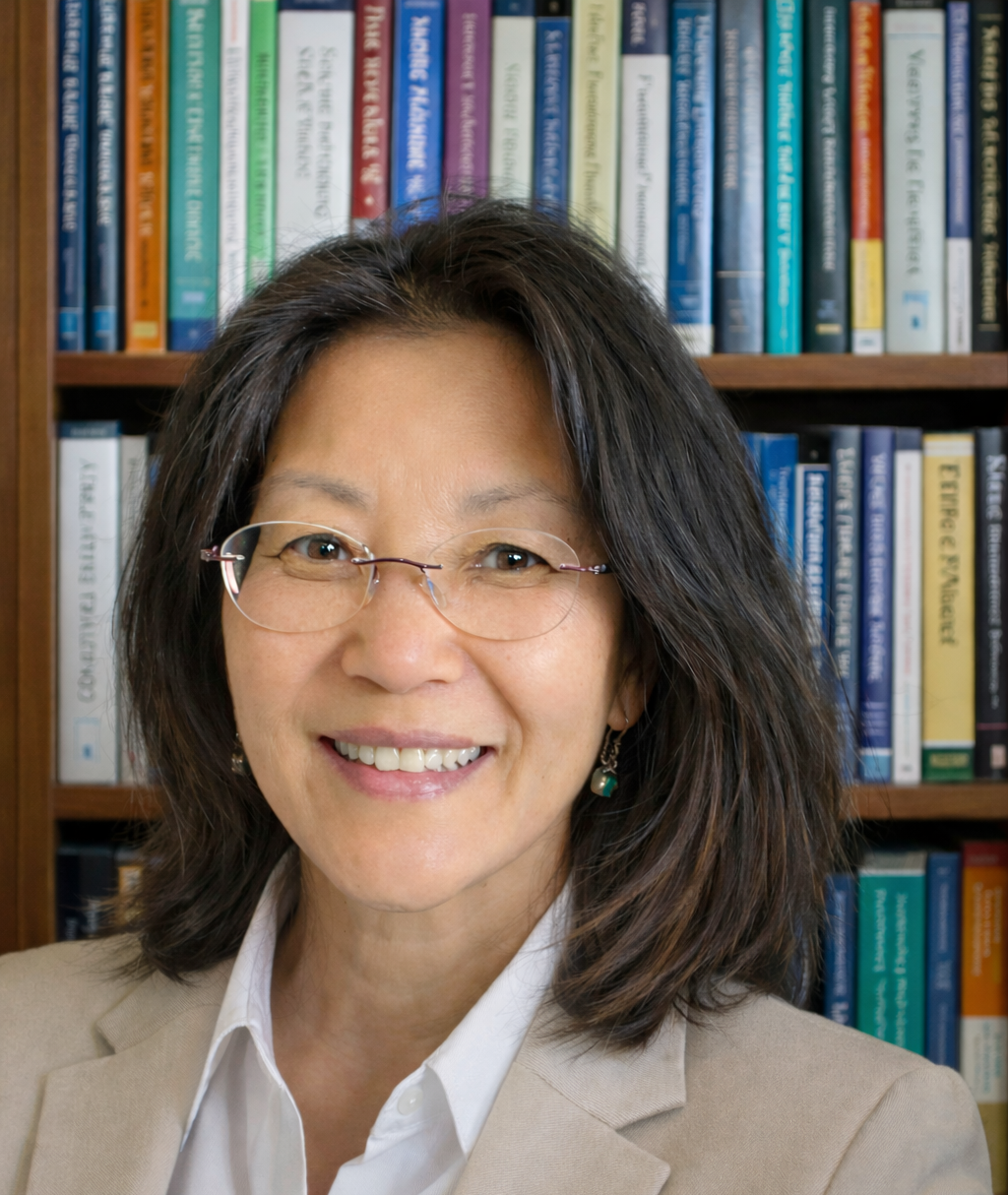 Maya Noel, licensed therapist at Inner Path LLC, smiling in front of a bookshelf
