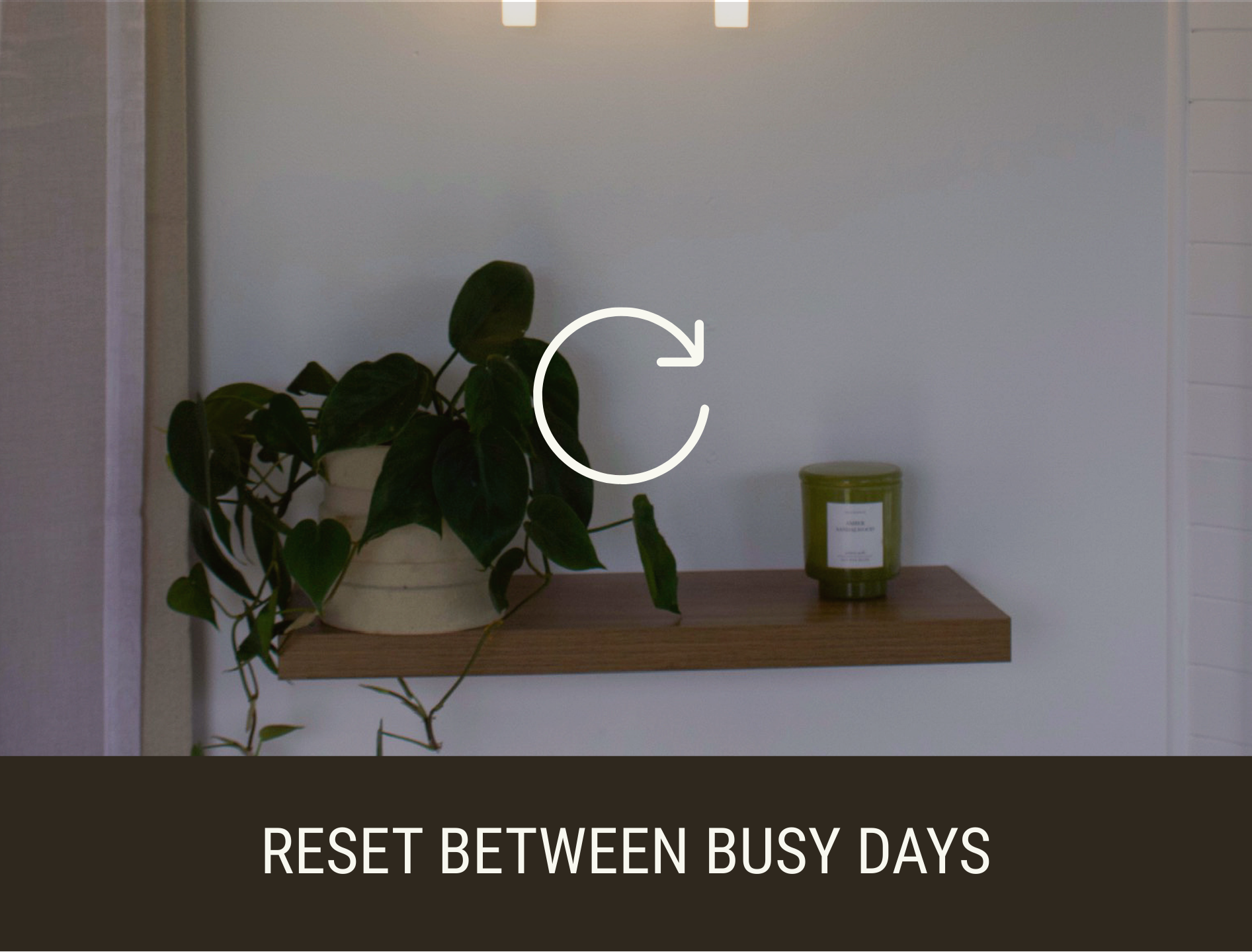A wall-mounted wooden shelf with a potted green leafy plant and a green candle in a jar. Text overlay reads 'RESET BETWEEN BUSY DAYS'.