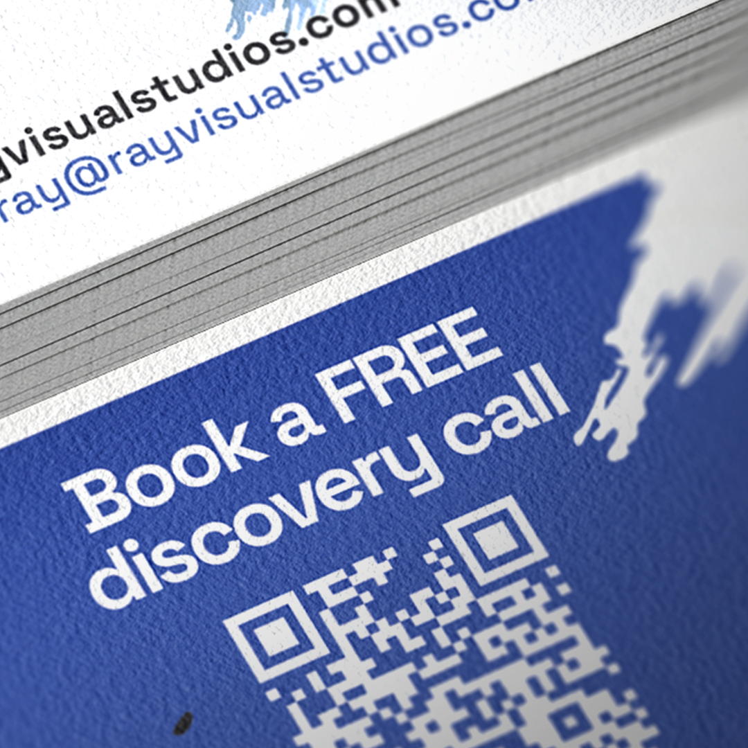 A stack of business cards with a blue background, white text that says "Book a FREE discovery call," and a QR code underneath.