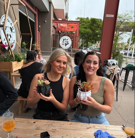 Two friends holding small plants at Lets Go Girls event