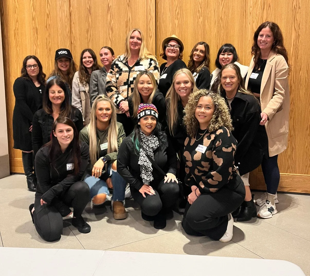 A diverse group of women networking and socializing at a 'Let's Go Girls' event in San Diego, smiling and building connections.