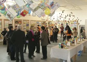 People browsing displays and tables at an indoor art or craft fair