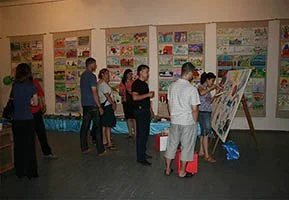Group of people viewing colorful artwork displayed on walls at an art exhibition