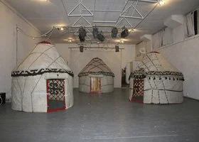Three traditional Native American teepees in an indoor setting.
