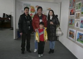 Three adults and one child standing in an art gallery with colorful artwork on the walls.