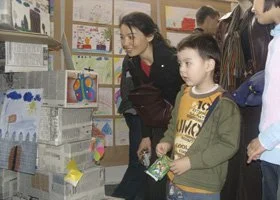 Children and adults looking at a display of paper rocket models