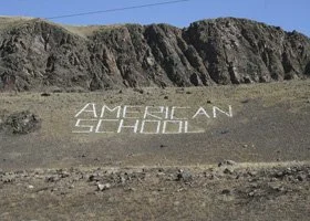 The words 'AMERICAN SCHOOL' written on a hillside.