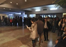 Crowd of people waiting in line inside a building, possibly for an event or to enter a venue.