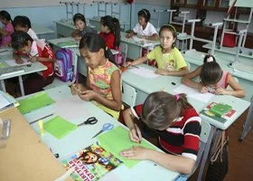 Children sitting at desks in a classroom, working on school activities.