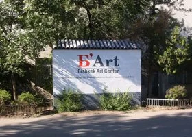 Sign for BHF Art, Bishkeik Art Center, with trees and greenery in the background.