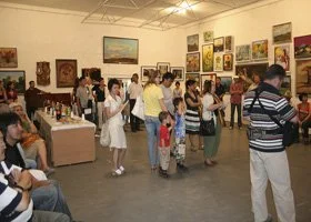 People browsing and viewing artwork at an art gallery or exhibition.