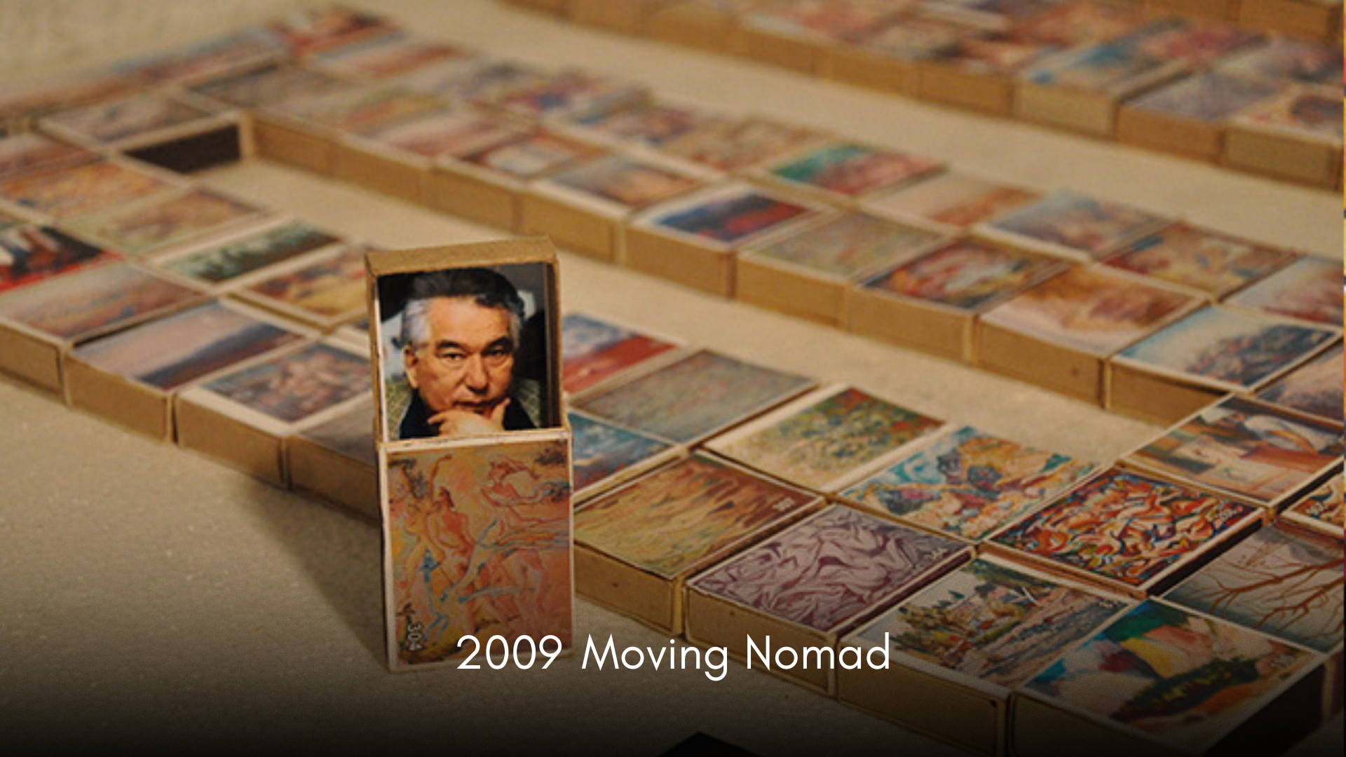A collection of small boxes arranged on a surface with an image of a man on the front, labeled "2009 Moving Nomad."