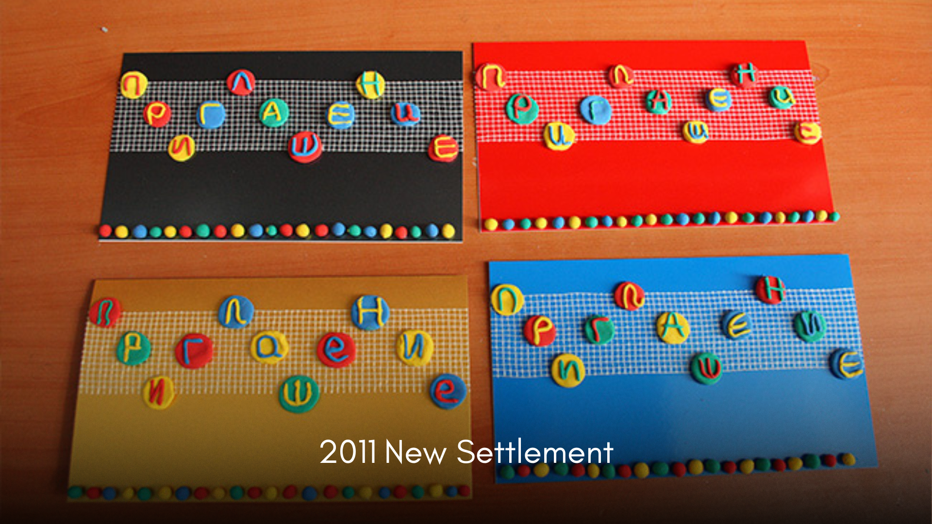 Four colorful paper boards with magnetic letters, decorated with small beads along the borders, arranged on a wooden surface.