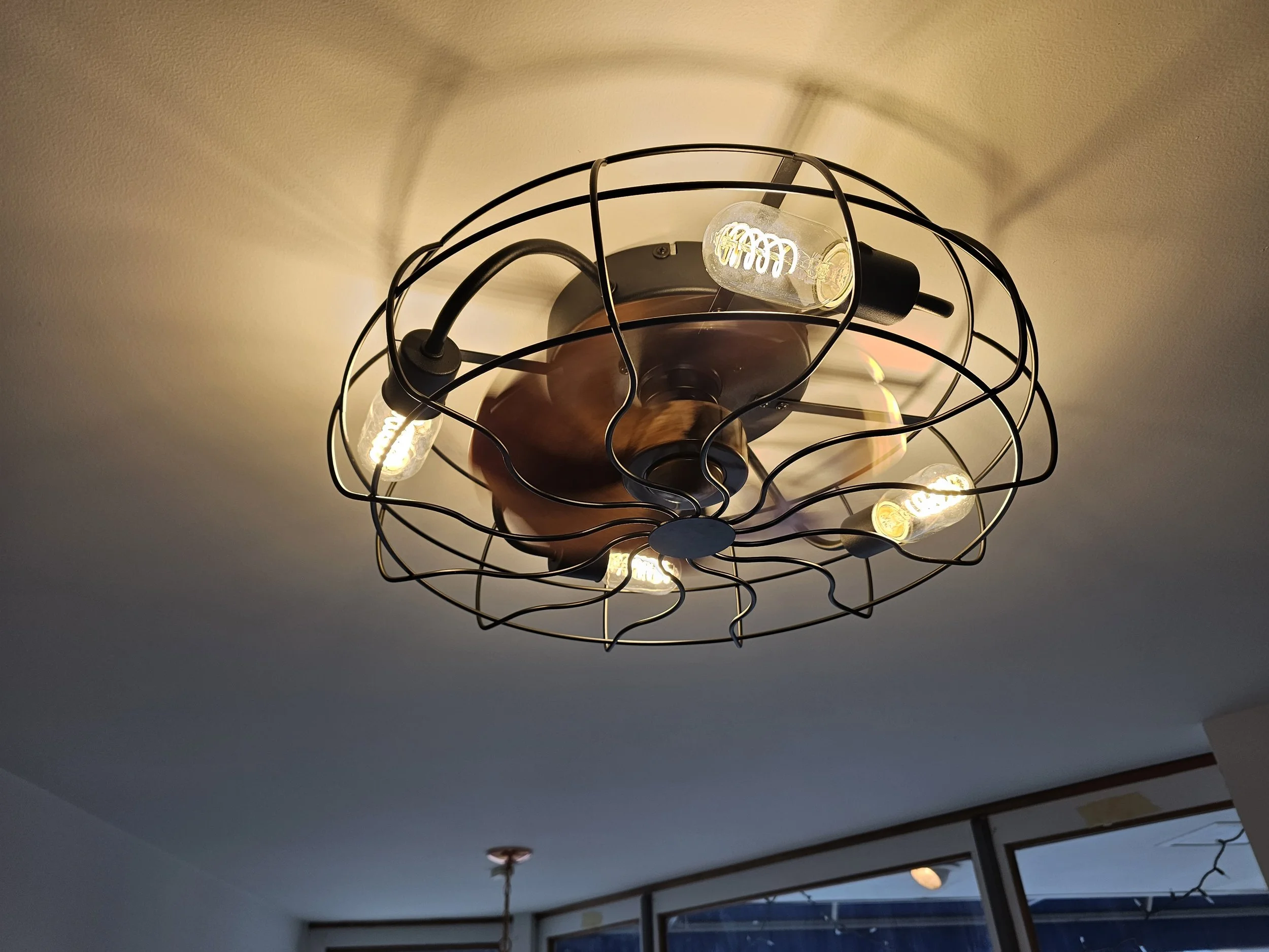Ceiling light fixture with exposed bulbs and a wire frame design.
