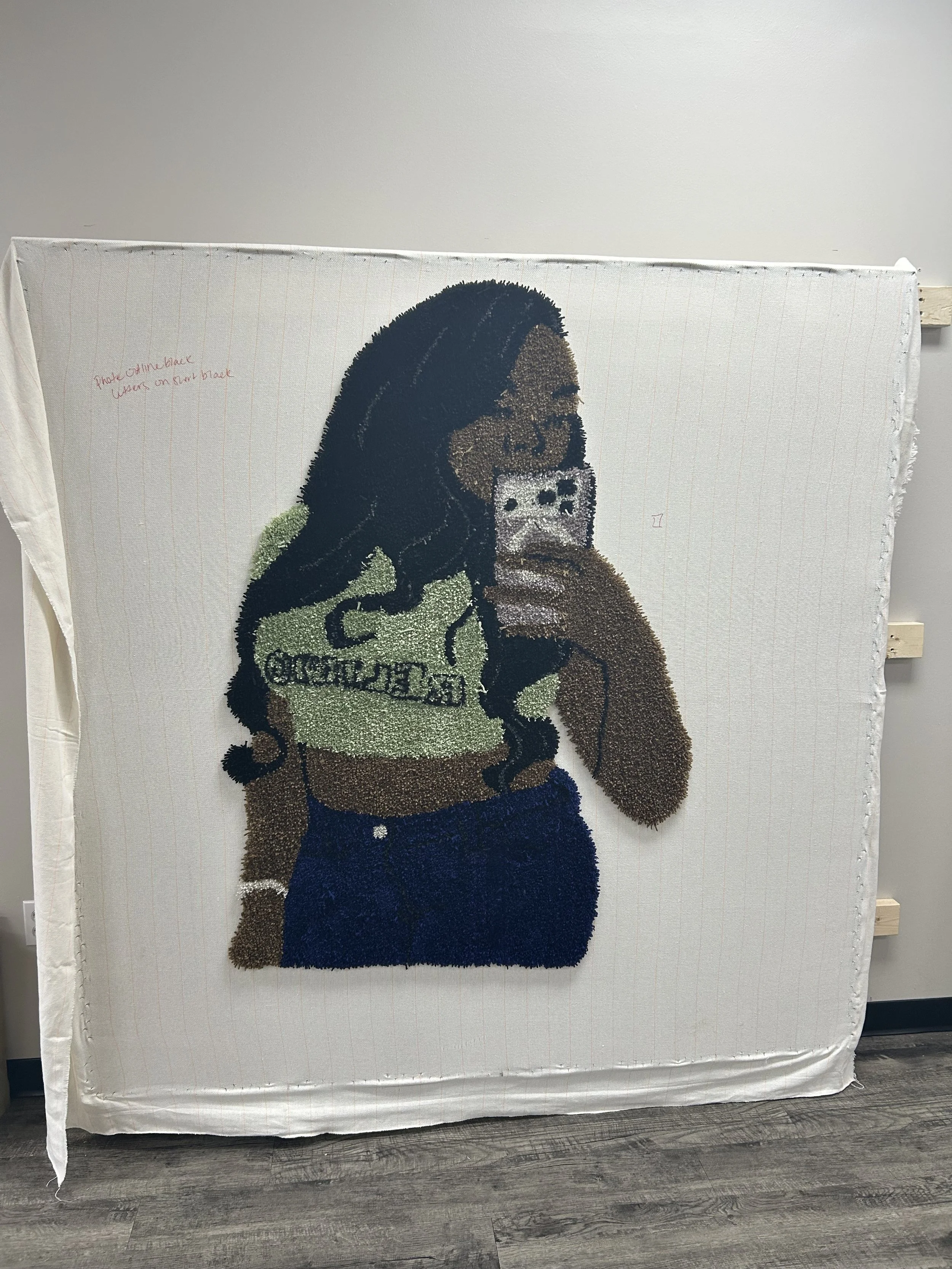A portrait of a woman with long dark hair taking a selfie in a mirror while holding a smartphone covered with a galaxy-themed case.