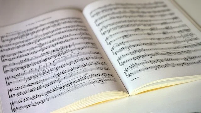 Closely cropped photo of an opened music book on a table