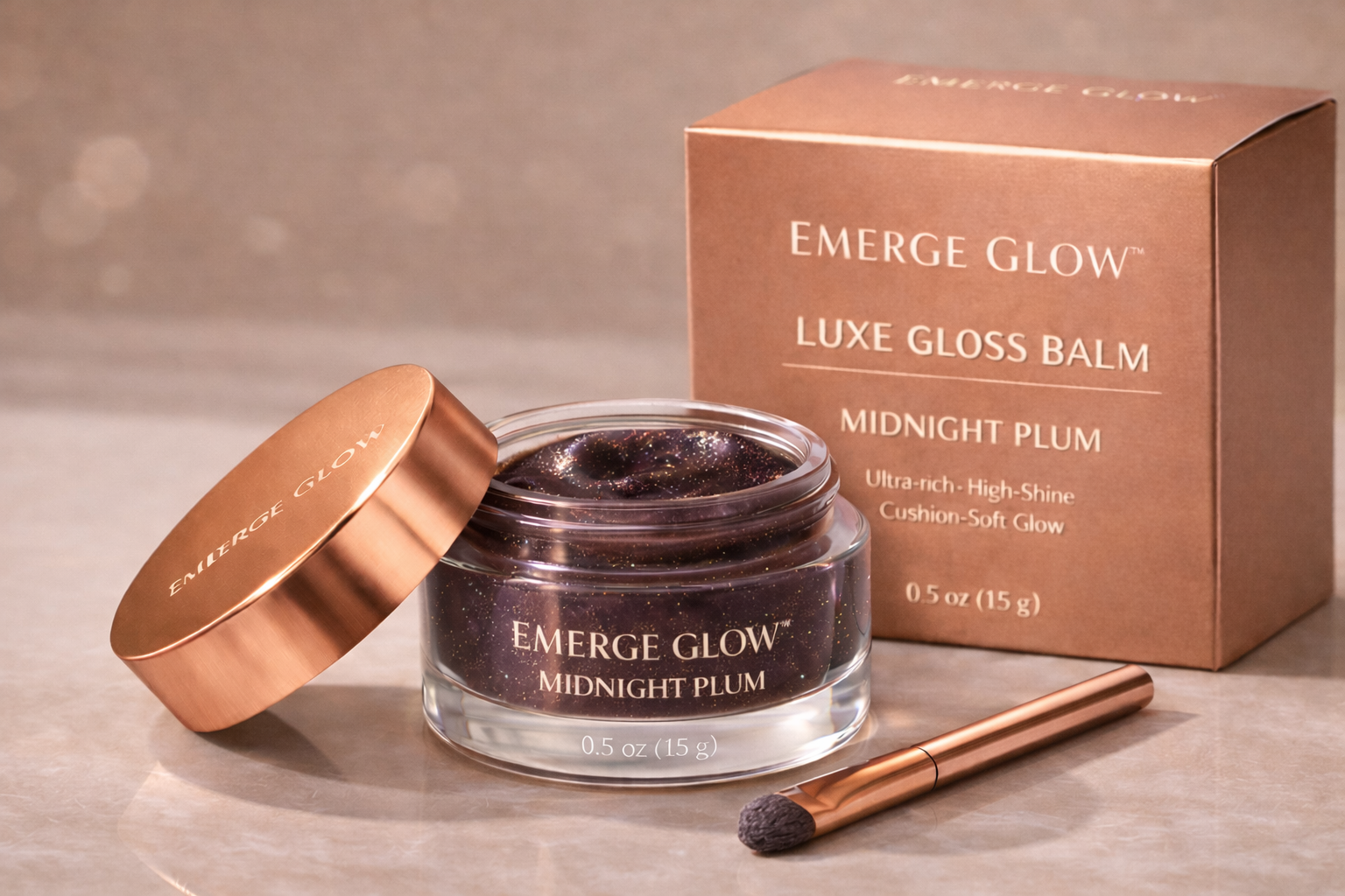 A jar of Emerge Glow Midnight Plum Luxe Gloss Balm with a gold lid, a matching gold applicator, and a box in the background displaying product details.
