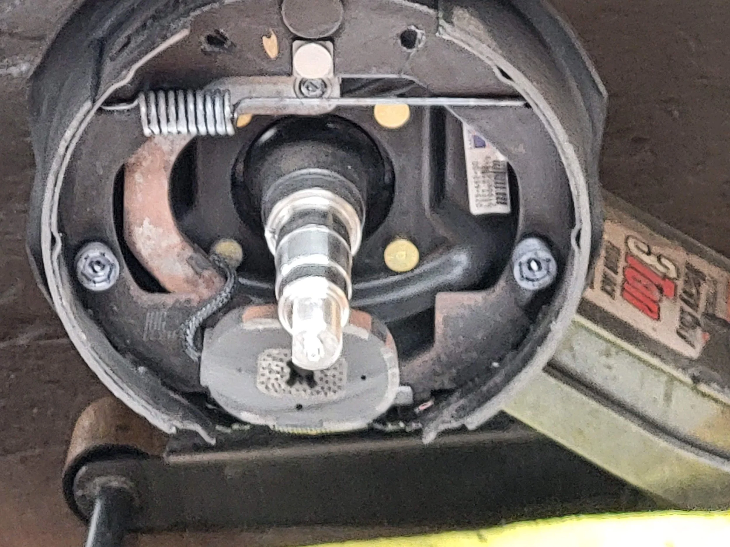 Close-up of a tractors' disc-cutting blade assembly, showing the central hub, springs, mounting screws, and part of the hydraulic system.