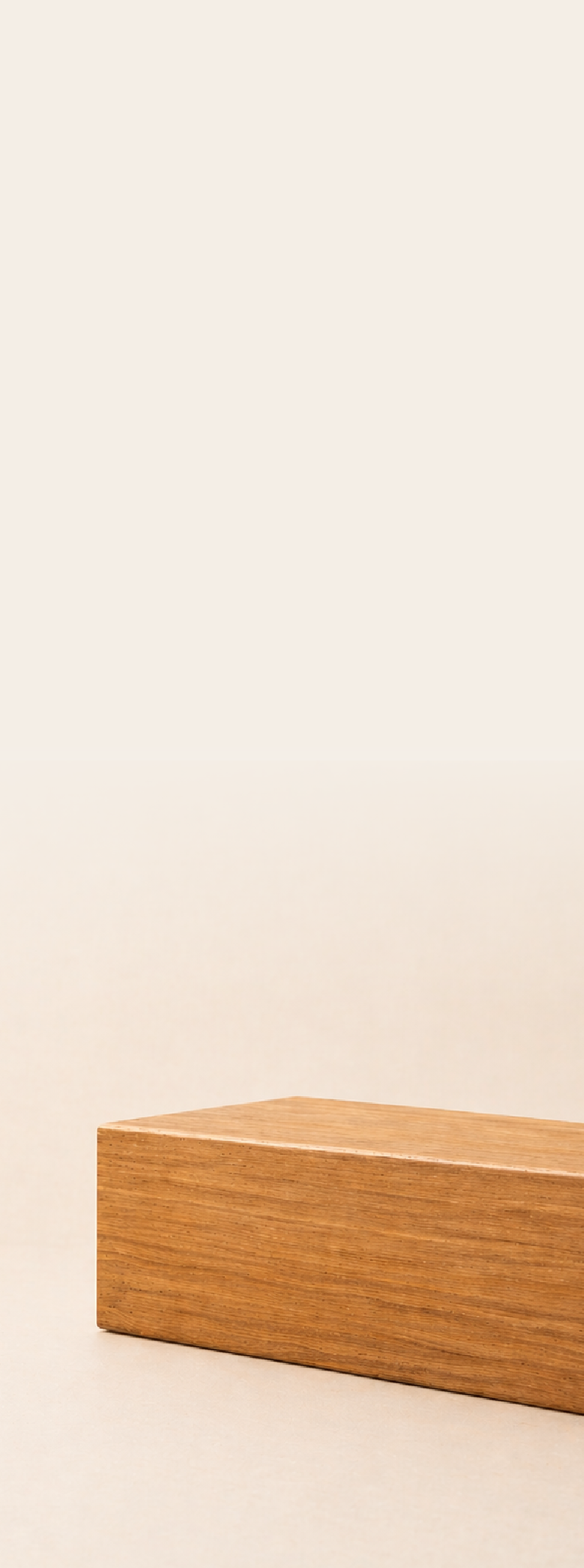 A wooden block with a smooth surface and a triangular shape placed on a plain white background.
