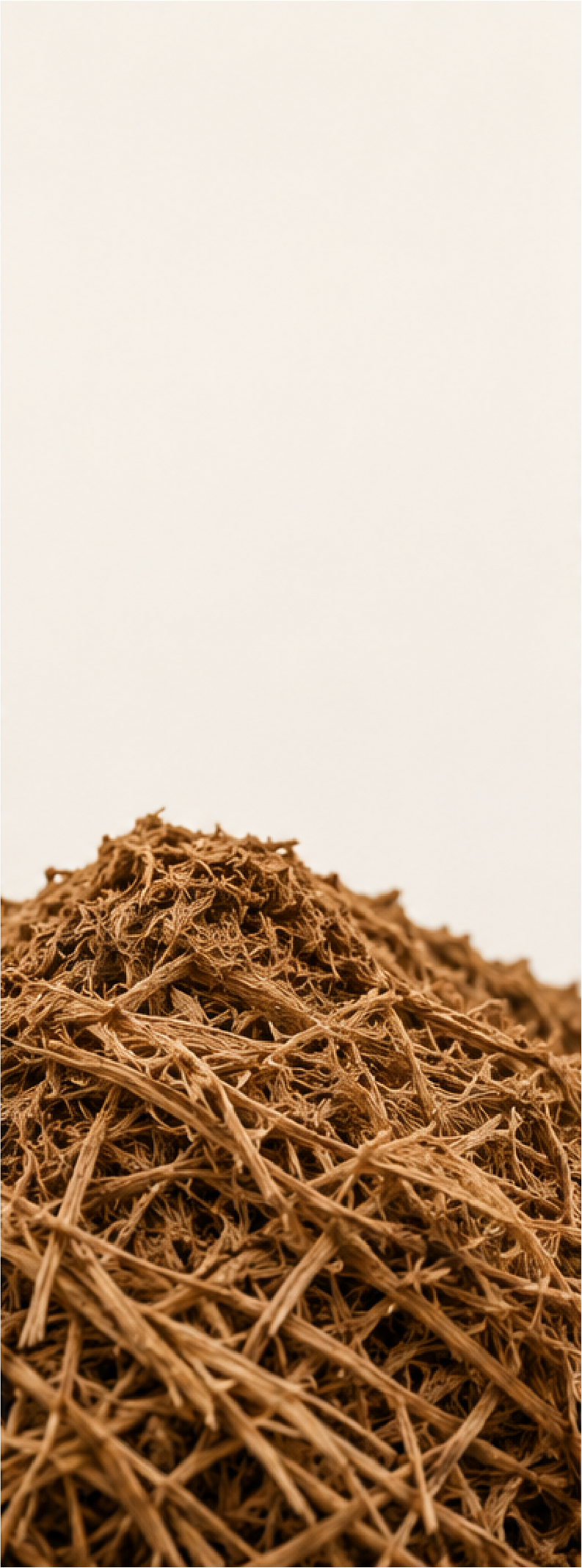 Close-up of a pile of brown shredded paper or straw against a white background.