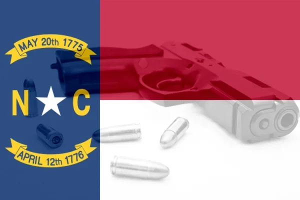 The image features the North Carolina state flag with a crossed-out handgun and several bullets. The flag shows the dates May 20th 1775 and April 12th 1776.