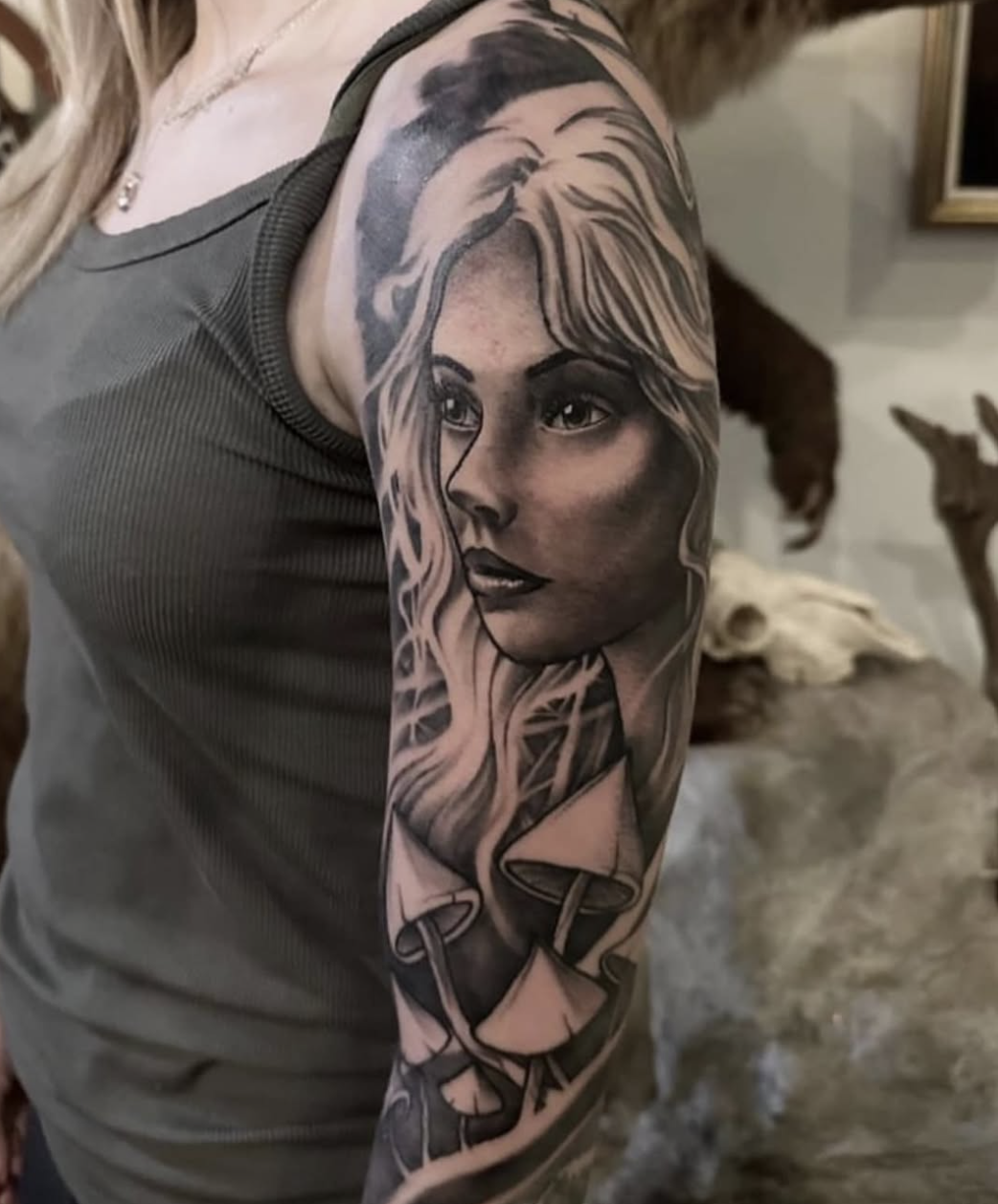 Black and grey arm tattoo featuring a detailed female portrait with flowing hair and mushrooms, completed by Cody Eckenrode at CREate Tattoo Studio.