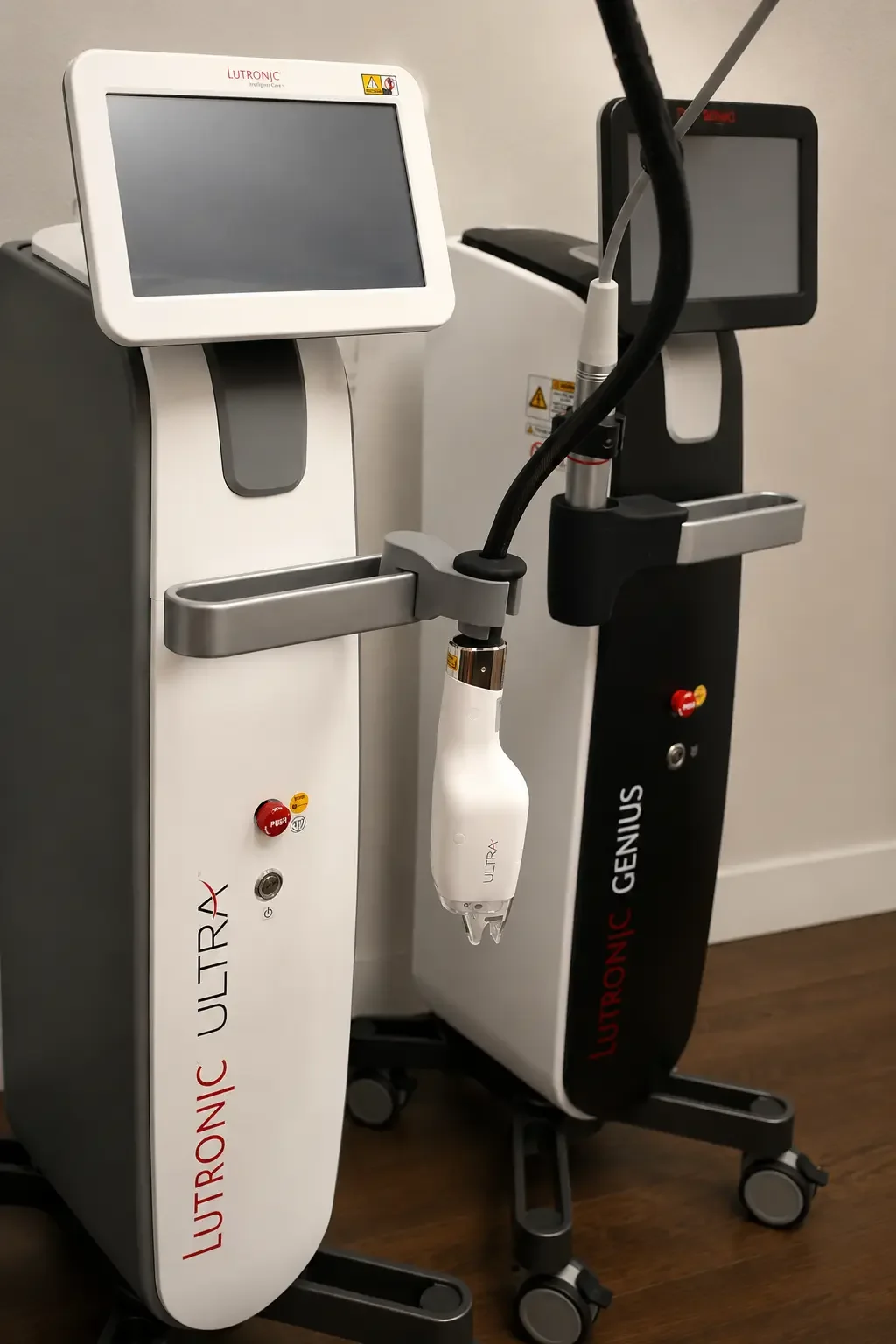 Medical devices with screens and attachments, used for skin treatments or procedures, labeled Lutronic Ultra and Genius.