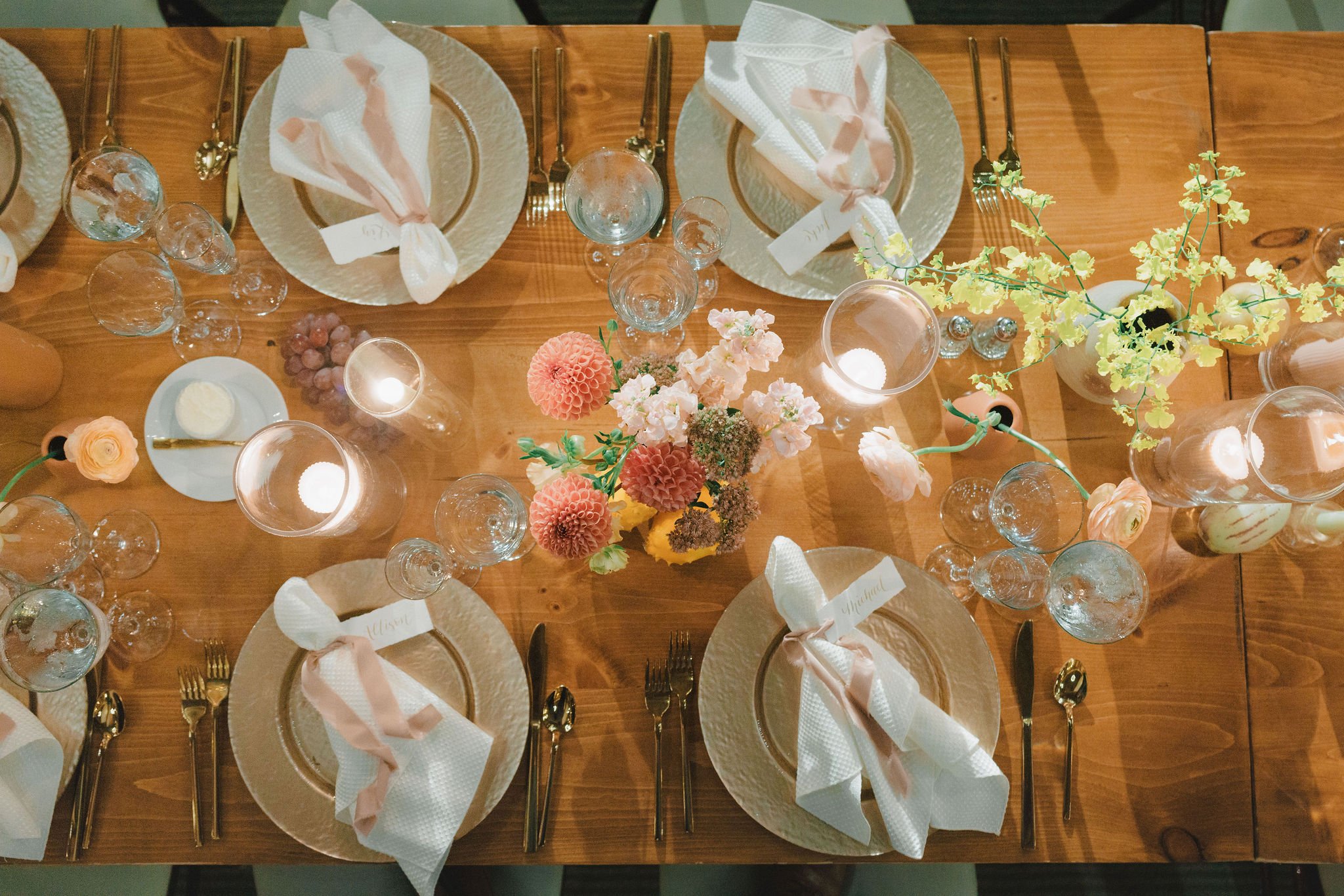 Custom calligraphy place cards with ribbon tied around a napkin with gold ink for a romantic wedding at The Barn at Gibbet Hill in Groton, MA