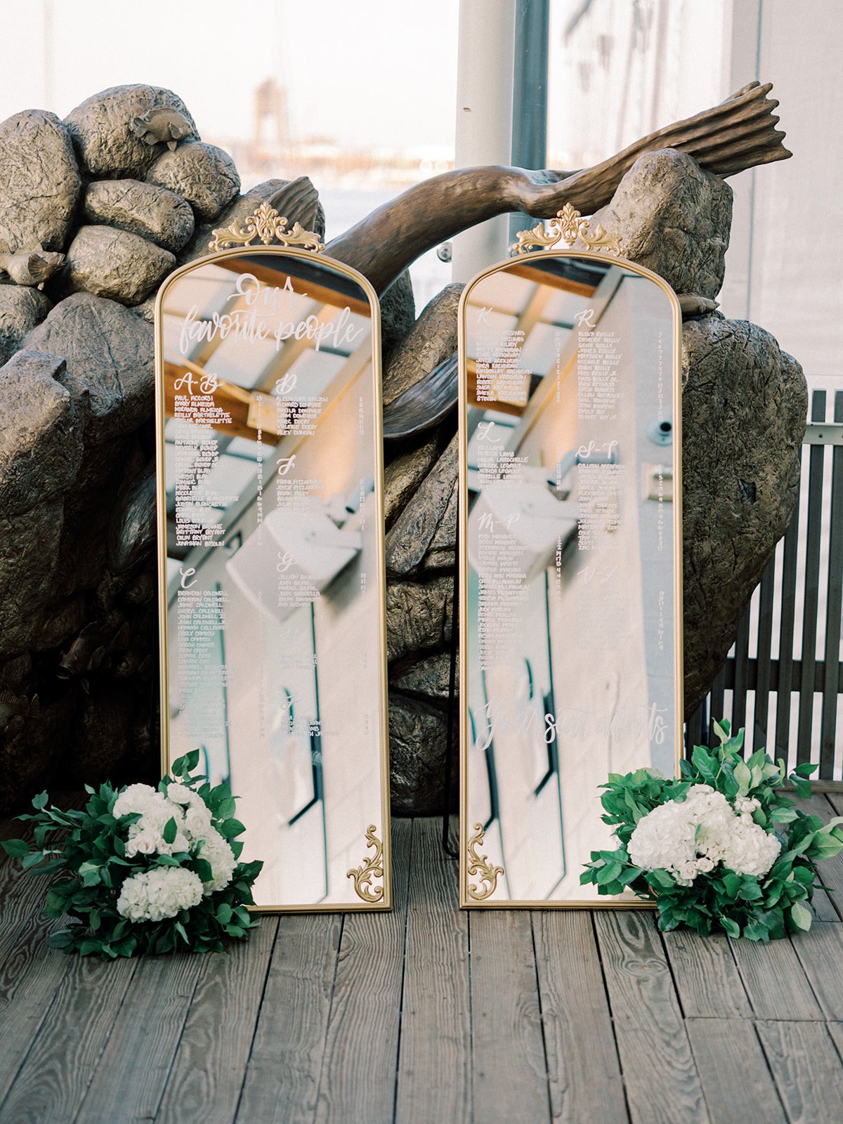 Vintage gold floor mirror with hand-lettered calligraphy seating chart for a classic Boston wedding at the New England Aquarium